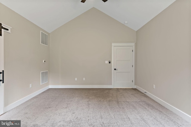 empty room with light carpet, vaulted ceiling, and ceiling fan