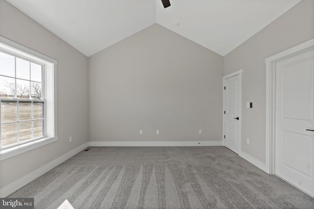 spare room with lofted ceiling and light colored carpet