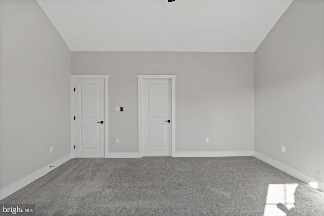 unfurnished bedroom featuring vaulted ceiling and light carpet