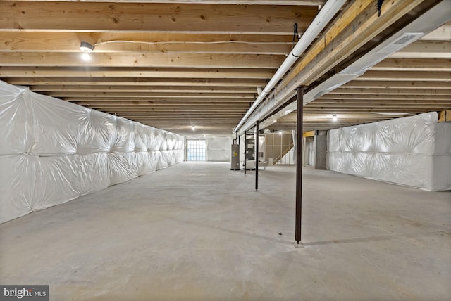 basement featuring heating unit and electric water heater