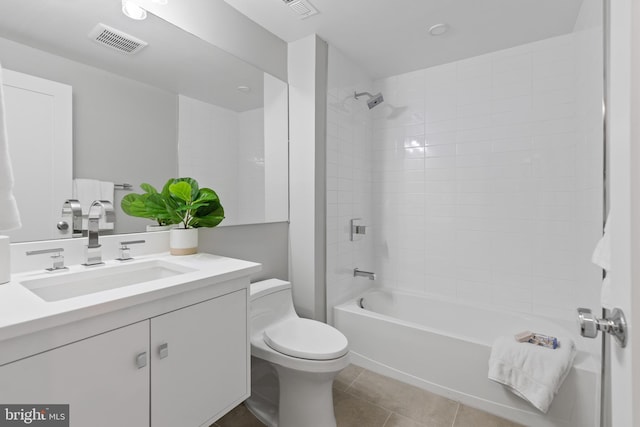 full bathroom featuring tile patterned flooring, tiled shower / bath combo, toilet, and vanity