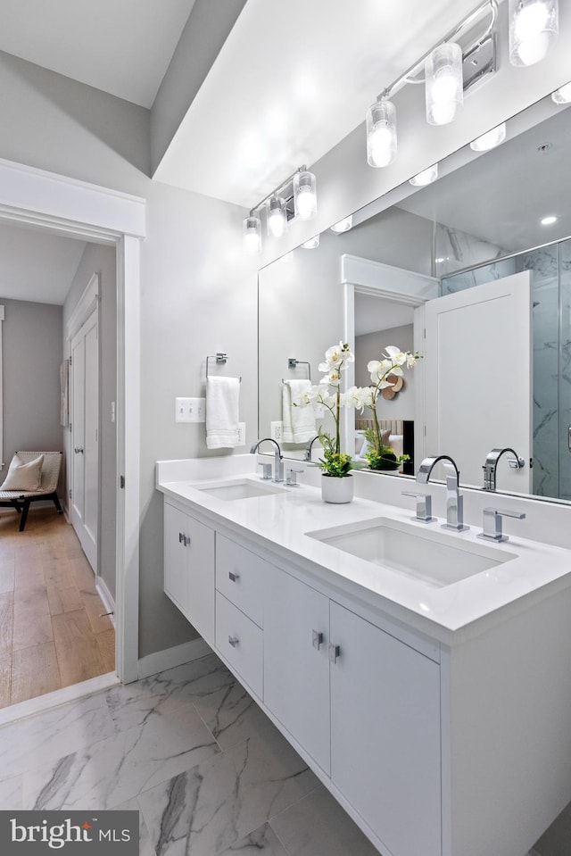 bathroom featuring vanity and a shower with door