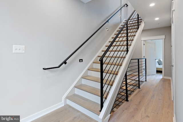 staircase with hardwood / wood-style floors