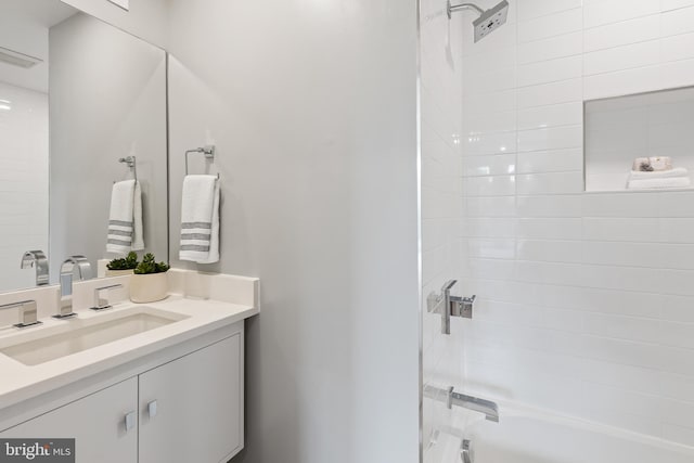 bathroom featuring vanity and tiled shower / bath