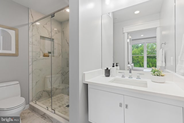 bathroom featuring vanity, toilet, and a shower with door