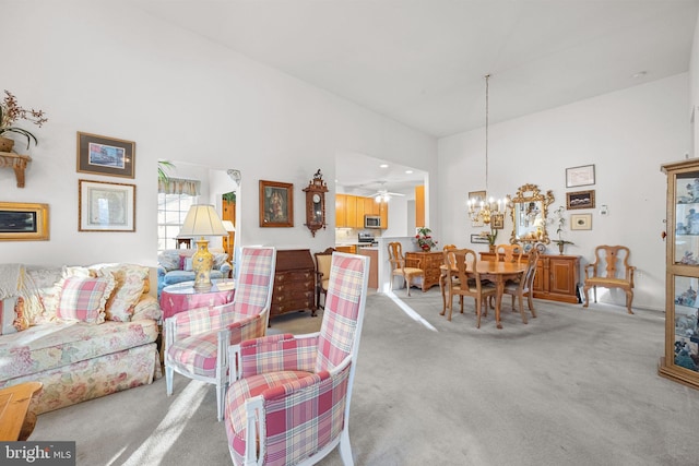 carpeted living room featuring a towering ceiling and ceiling fan with notable chandelier