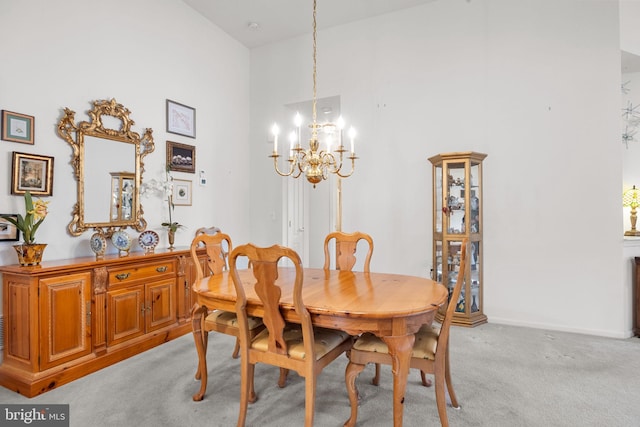 carpeted dining area with a towering ceiling and a chandelier