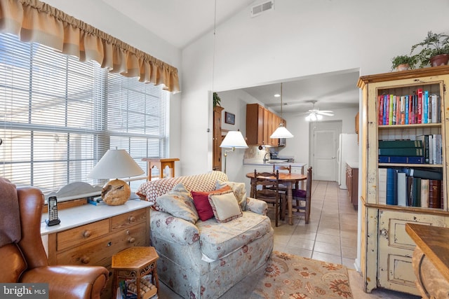 living room with light tile patterned flooring, ceiling fan, lofted ceiling, and a wealth of natural light