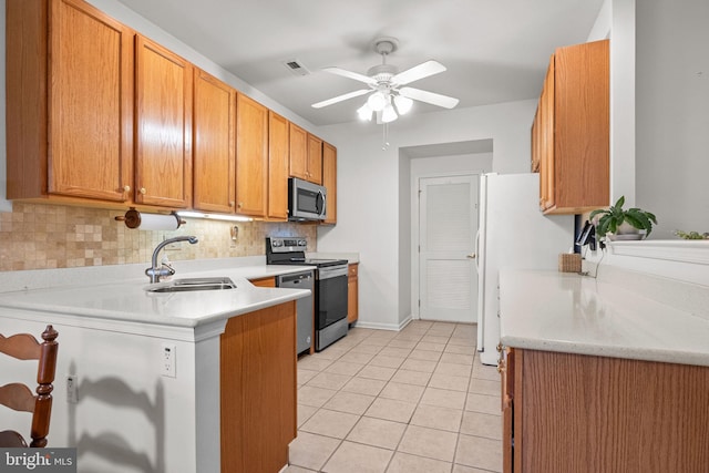 kitchen with appliances with stainless steel finishes, tasteful backsplash, sink, light tile patterned floors, and ceiling fan