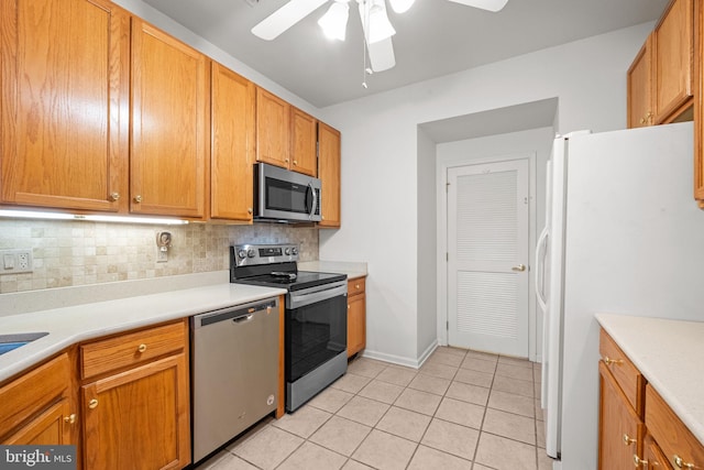 kitchen with tasteful backsplash, light tile patterned flooring, ceiling fan, and appliances with stainless steel finishes