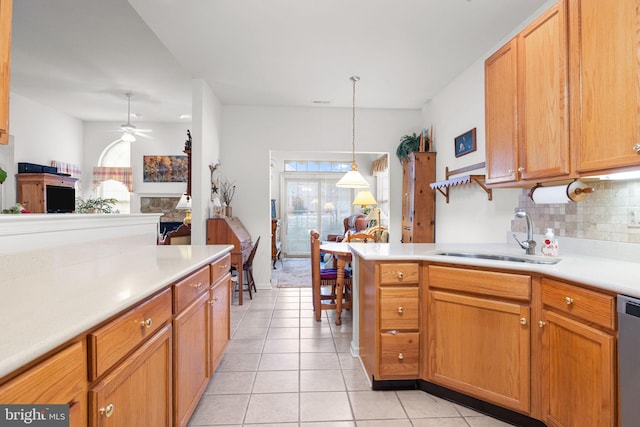 kitchen with sink, hanging light fixtures, light tile patterned floors, ceiling fan, and decorative backsplash