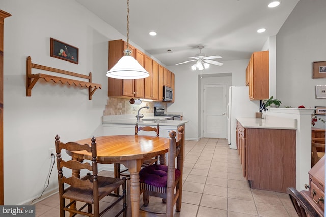 kitchen with decorative light fixtures, light tile patterned floors, ceiling fan, stainless steel appliances, and backsplash