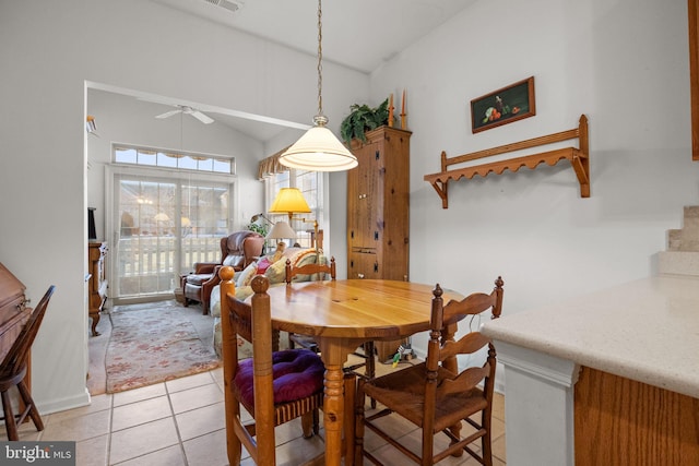 tiled dining space featuring lofted ceiling and ceiling fan