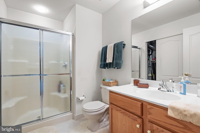 bathroom with vanity, toilet, and a shower with door