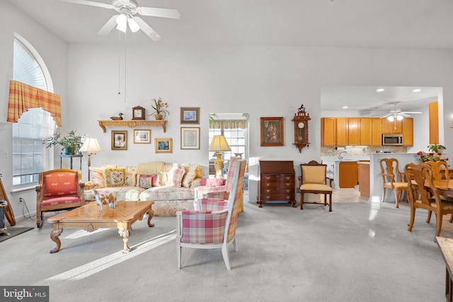 living room with light colored carpet and ceiling fan