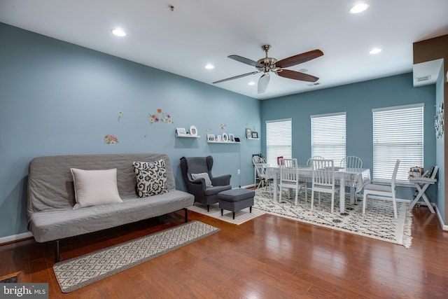 living room featuring ceiling fan and dark wood-type flooring