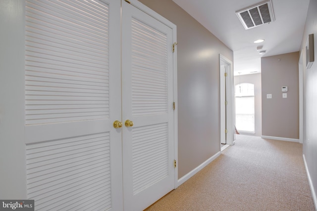 hall featuring light colored carpet