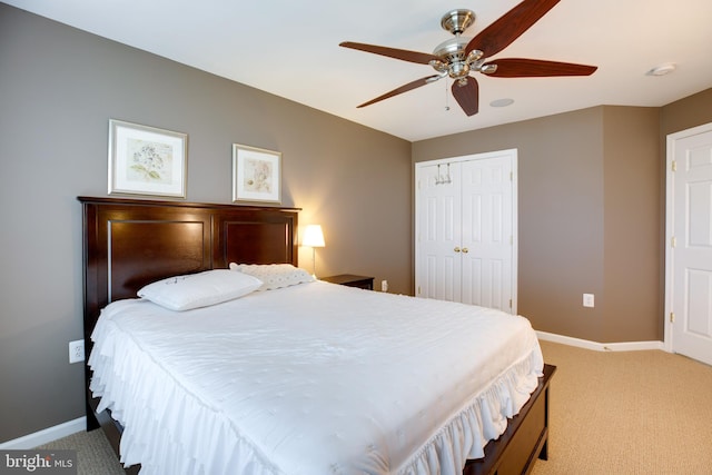 carpeted bedroom with ceiling fan and a closet