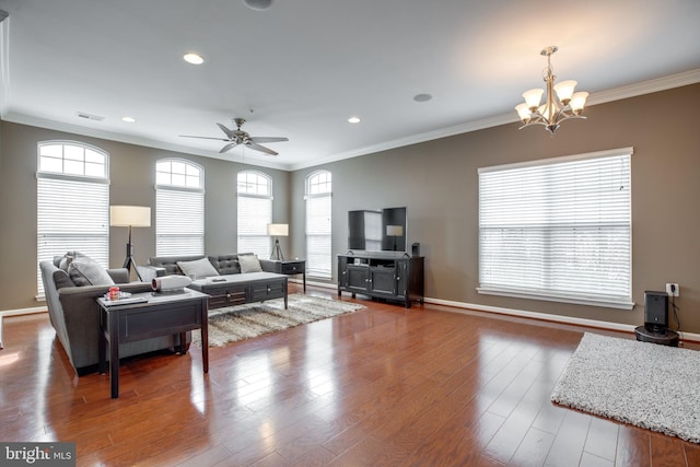 living room featuring hardwood / wood-style floors, ceiling fan with notable chandelier, a healthy amount of sunlight, and ornamental molding