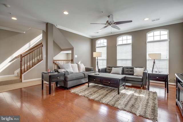 living room featuring hardwood / wood-style floors, ceiling fan, and crown molding