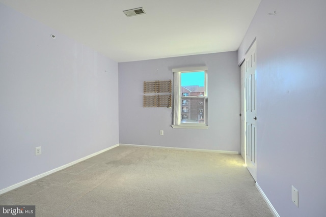 unfurnished room featuring light carpet