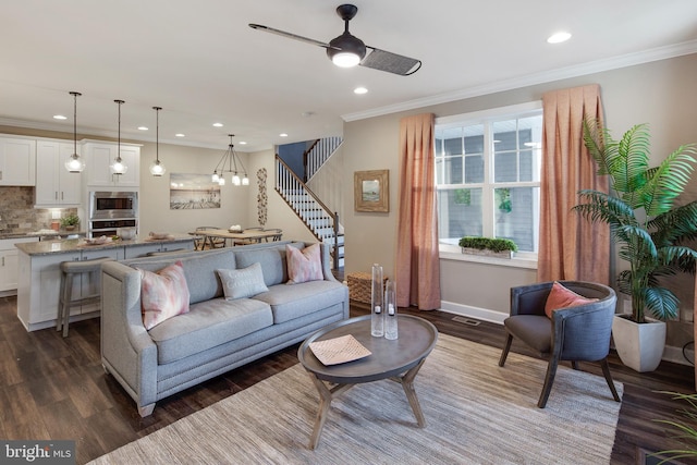 living room featuring dark hardwood / wood-style floors, ceiling fan, and crown molding