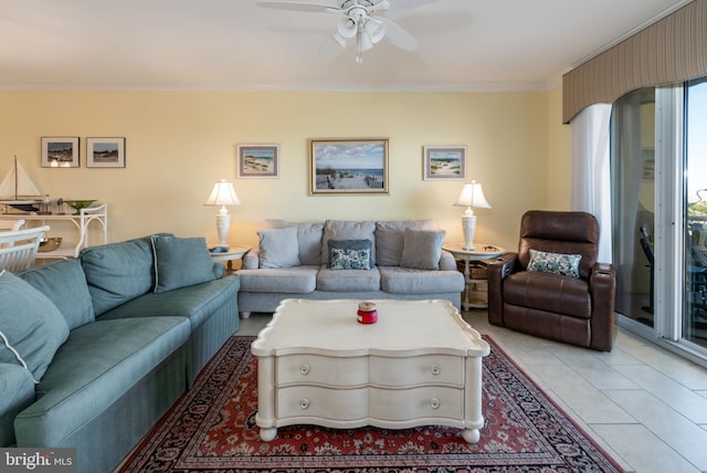 tiled living room with ceiling fan and ornamental molding