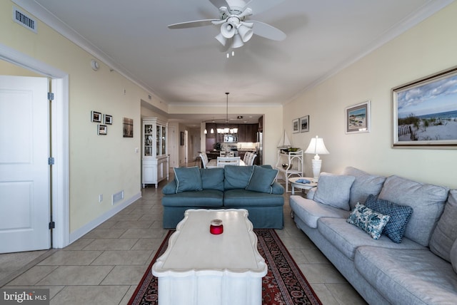 living room with light tile patterned floors, ceiling fan with notable chandelier, and ornamental molding