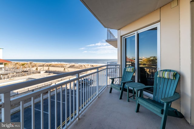 balcony with a water view and a beach view