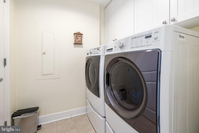 laundry area featuring light tile patterned floors, cabinets, separate washer and dryer, and electric panel