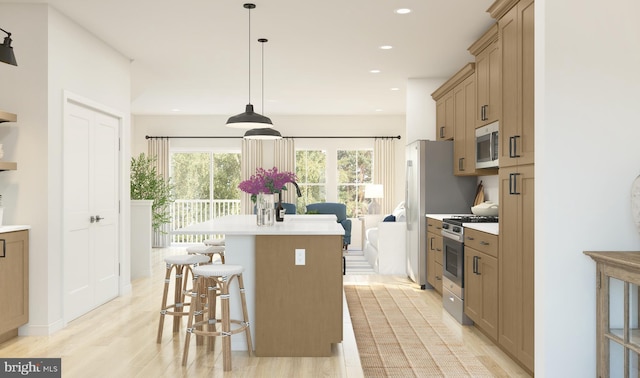 kitchen with stainless steel appliances, a kitchen breakfast bar, light hardwood / wood-style flooring, pendant lighting, and a kitchen island with sink