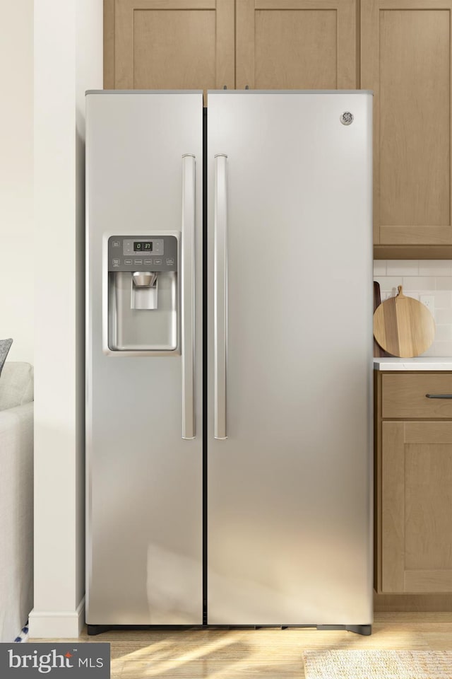 kitchen featuring stainless steel refrigerator with ice dispenser, light brown cabinetry, and light hardwood / wood-style flooring