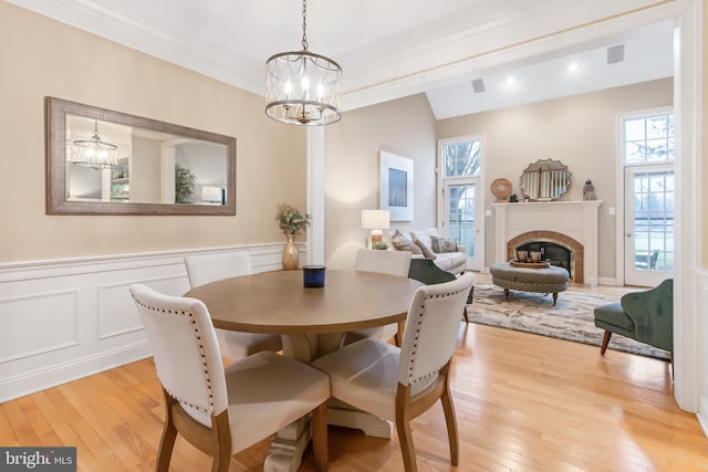 dining area featuring a wealth of natural light, crown molding, a chandelier, and light wood-type flooring