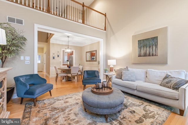 living room featuring hardwood / wood-style flooring, a high ceiling, and an inviting chandelier