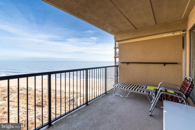 balcony featuring a water view and a view of the beach