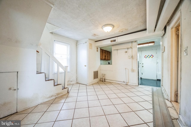 tiled foyer with a textured ceiling