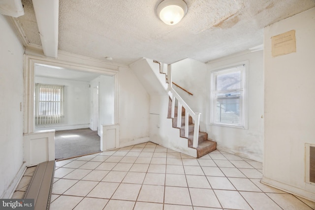 stairway featuring carpet floors and a textured ceiling