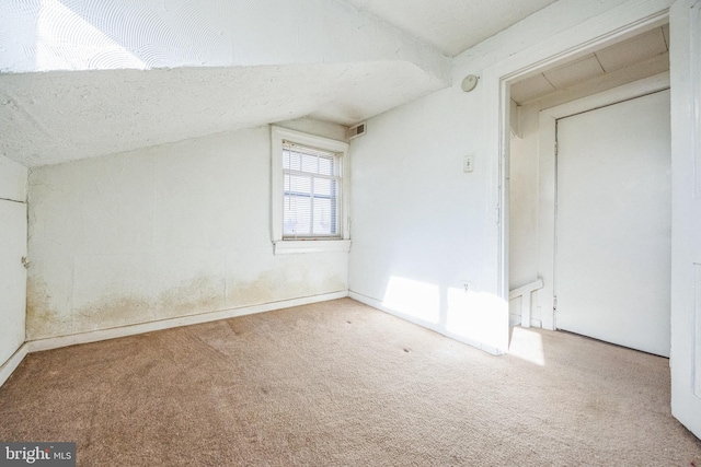 additional living space with lofted ceiling and carpet flooring