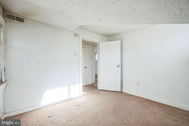 carpeted empty room with a textured ceiling