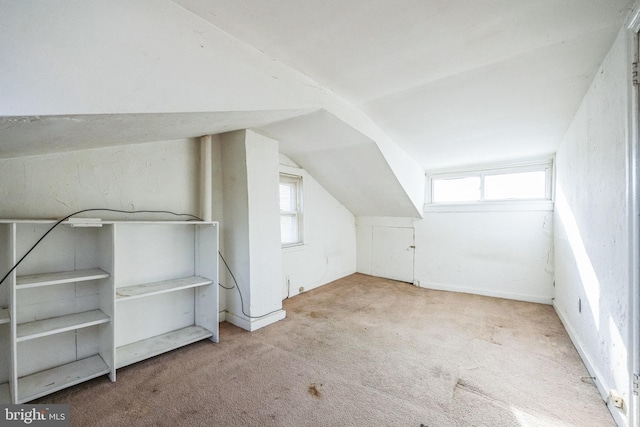 bonus room featuring plenty of natural light, vaulted ceiling, and light carpet