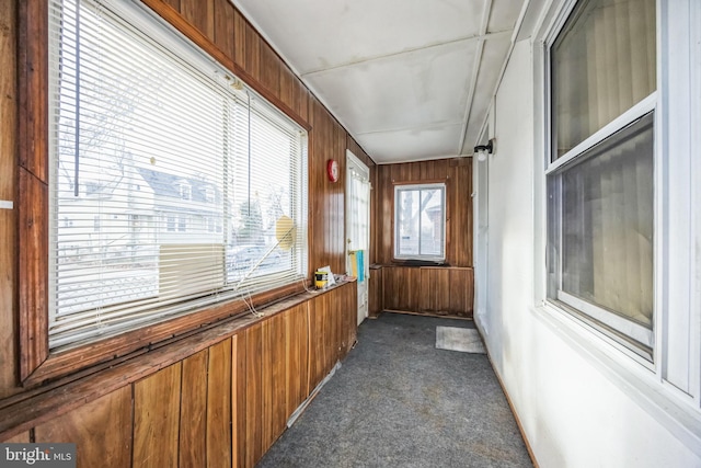 interior space with wooden walls and dark colored carpet