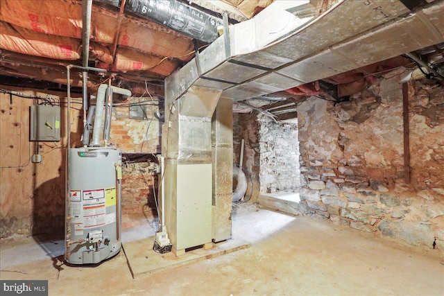 basement featuring electric panel, gas water heater, and heating unit