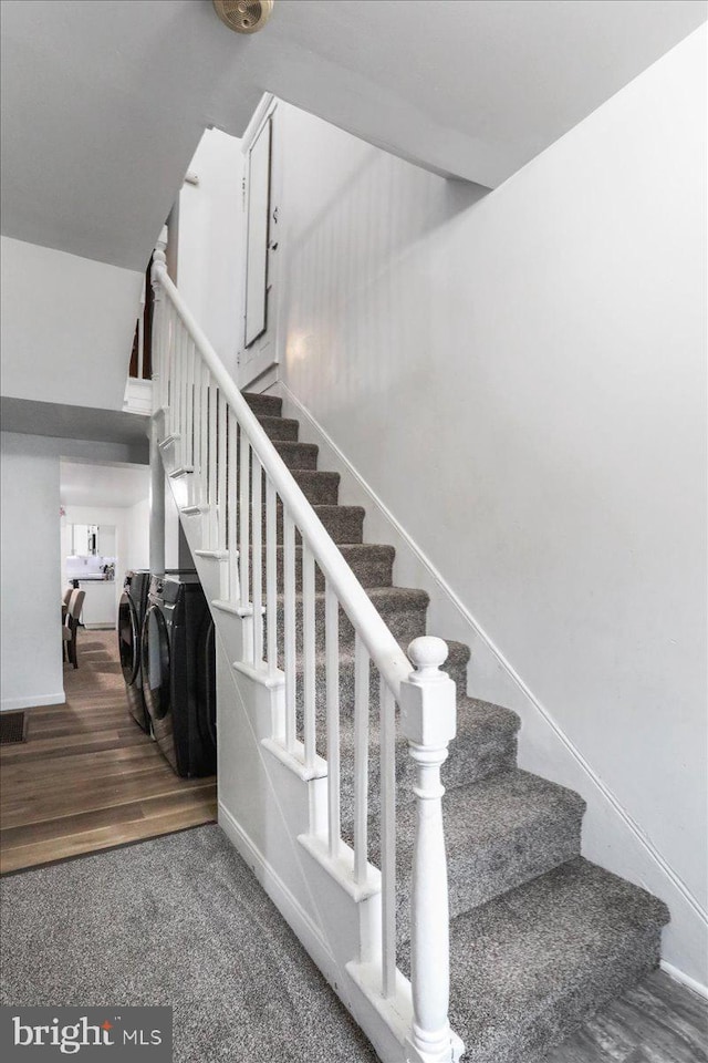 stairs featuring washing machine and dryer and wood-type flooring