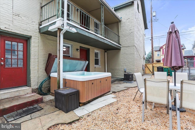 view of patio / terrace featuring a balcony and a hot tub