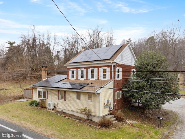 view of side of property with ac unit and solar panels