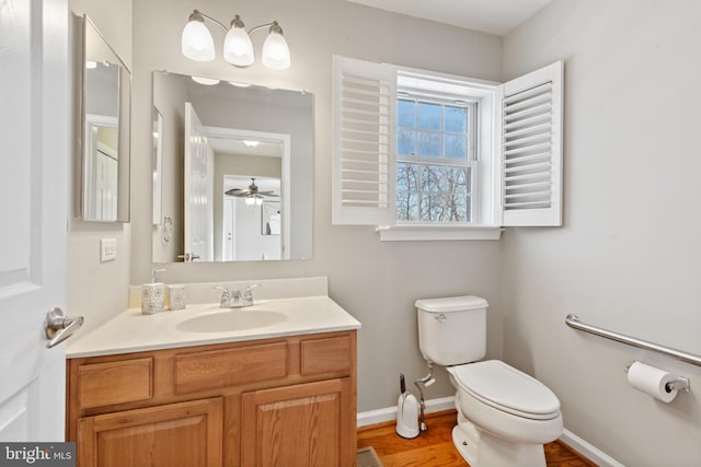 bathroom with ceiling fan, vanity, hardwood / wood-style flooring, and toilet