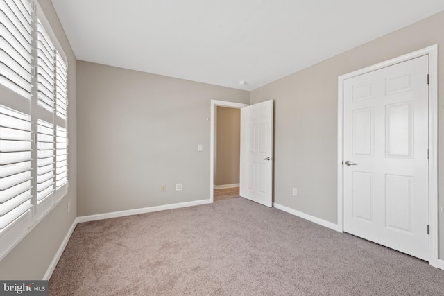 unfurnished bedroom featuring light carpet