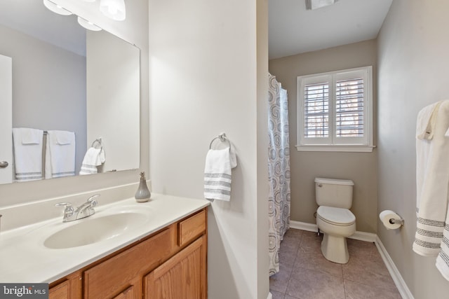 bathroom with tile patterned flooring, vanity, and toilet