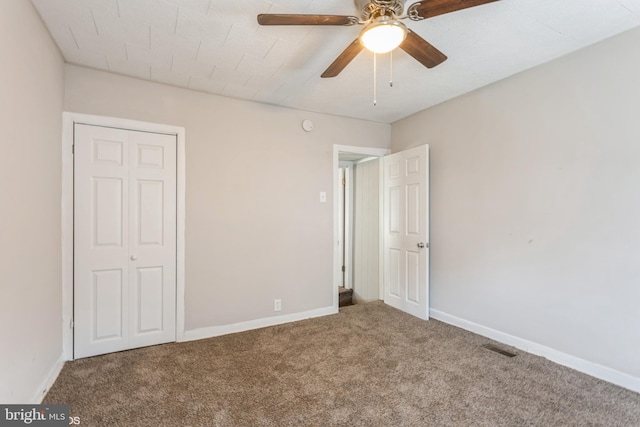 unfurnished bedroom with ceiling fan, a closet, and carpet floors