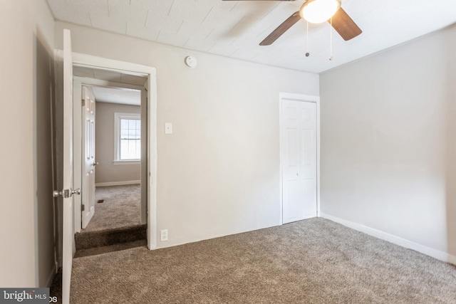 empty room with ceiling fan and carpet